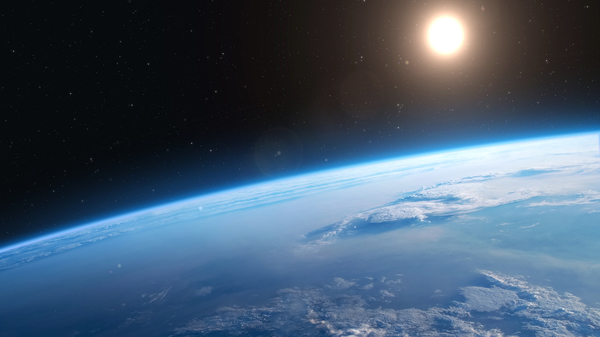 Sun seen from Earth&rsquo;s orbit, blue ocean below.